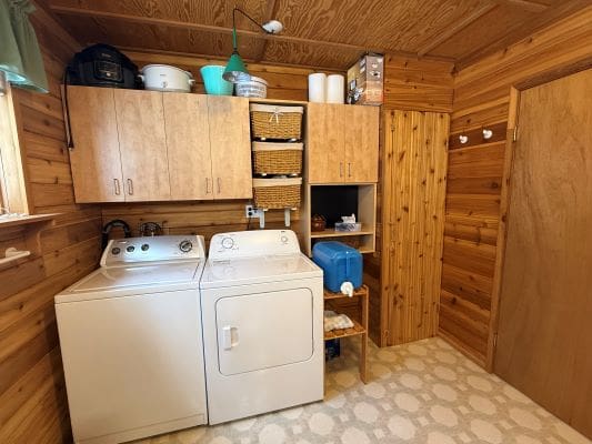 Wood-paneled laundry room with washer and dryer.