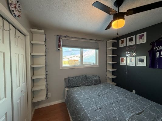 Modern bedroom with shelves and wall art.