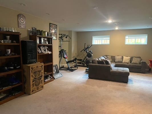 Basement with gym equipment and seating area.