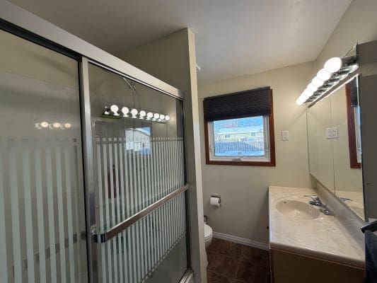 Modern bathroom with shower and vanity lighting.