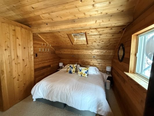 Cozy wooden bedroom with skylight window.
