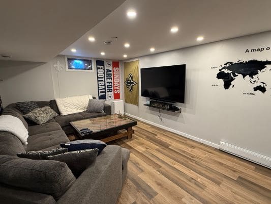 Cozy basement with sectional sofa and decor.