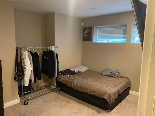 Minimalist bedroom with bed and clothes rack.