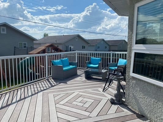 Sunny deck with blue chairs and railing.