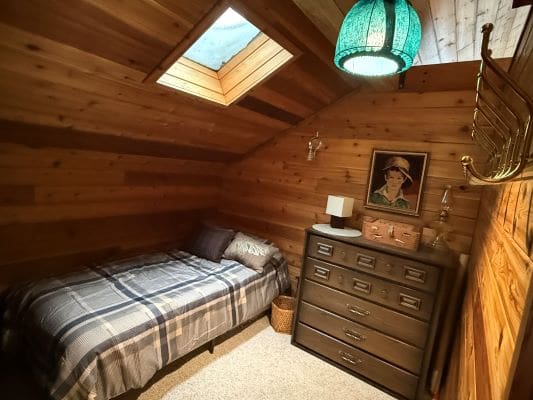 Cozy attic bedroom with wooden walls.