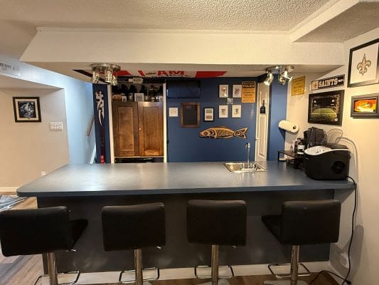 Home bar with four black stools.