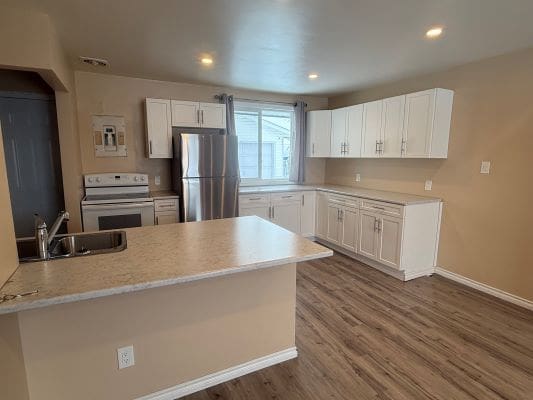 Modern kitchen with white cabinets and appliances.