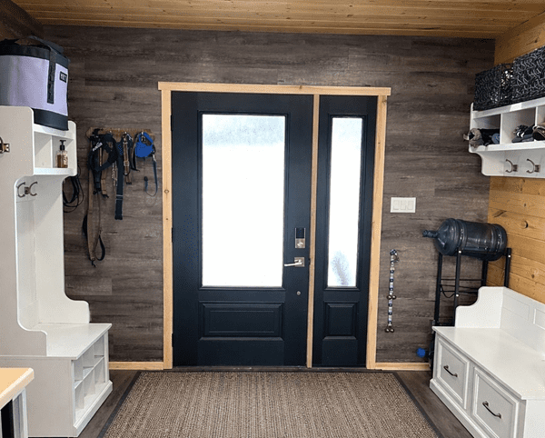 Mudroom with black door and storage benches.
