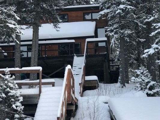 Wooden cabin surrounded by snow-covered trees.