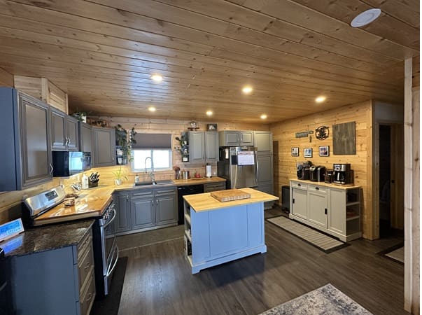 Rustic kitchen with wooden ceiling and cabinets.
