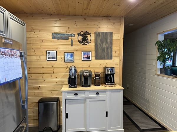 Coffee station with wooden wall decor.