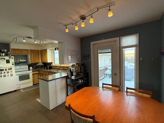 Modern kitchen and dining area with lighting.
