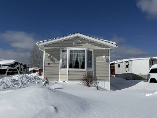 Mobile home surrounded by snow.