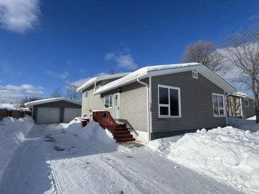 House with snow-covered yard and driveway.