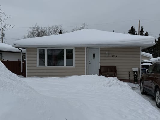 Single-story house with snow-covered roof.