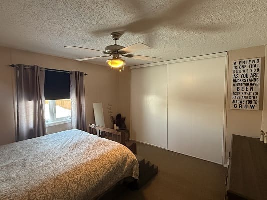 Bedroom with bed, window, and closet door.