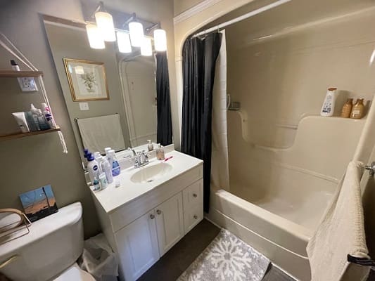 Compact bathroom with shower and vanity area.