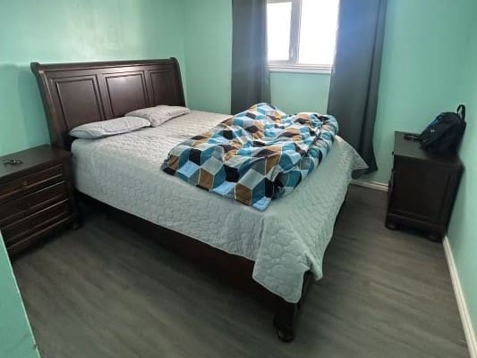 Bedroom with wooden furniture and geometric bedding.