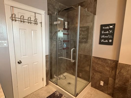 Glass shower enclosure in a modern bathroom.