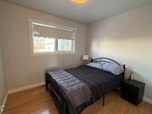 Simple bedroom with bed and side table.
