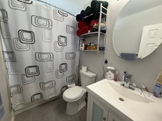Modern bathroom with shower and round mirror.