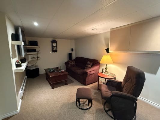 Cozy basement living room with brown furniture.