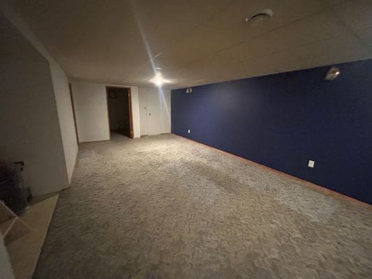 Empty basement room with blue accent wall.