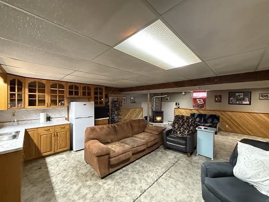 Basement living room with kitchenette and sofas.