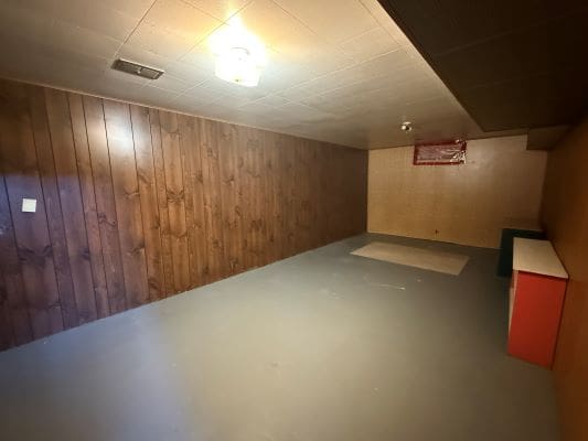 Basement room with wood panel walls.