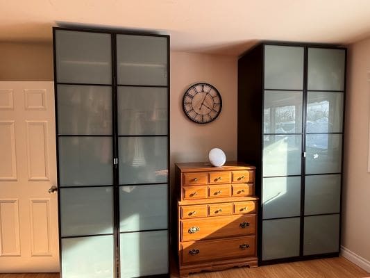 Wardrobes and dresser with wall clock.