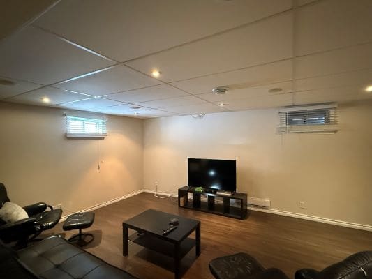 Basement living room with TV and seating.