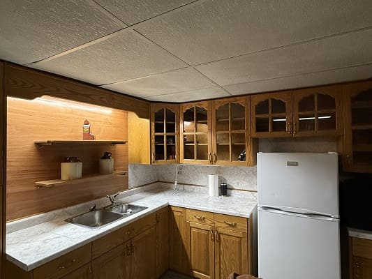 Wooden kitchen with fridge and cabinets.