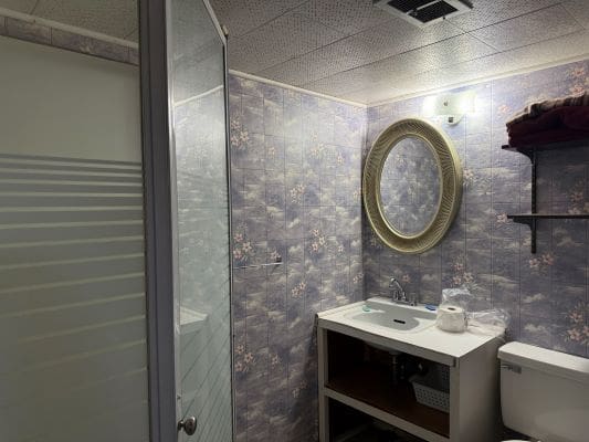 Small bathroom with mirror and shower.