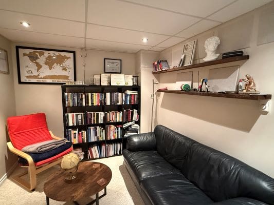 Cozy home office with books and sofa.