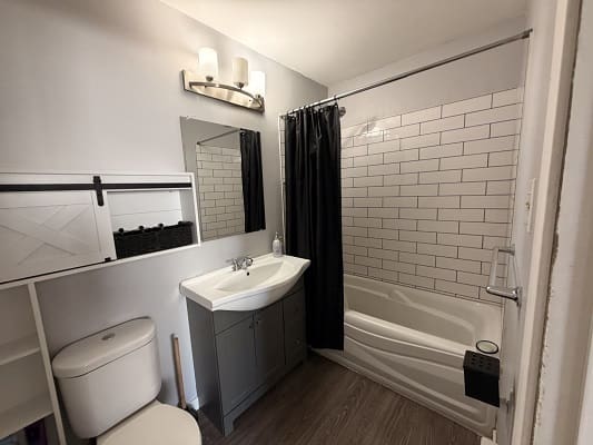 Modern bathroom with shower and dark curtain.
