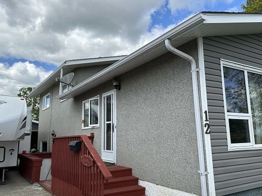 Gray house with red steps and siding.