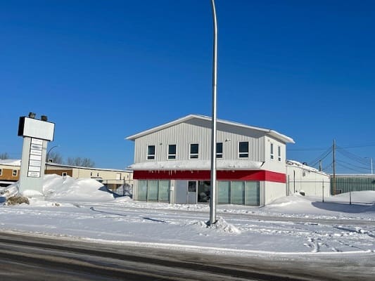 Snowy street with a two-story building.