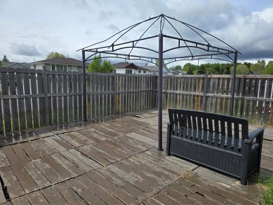 Wooden deck with bench and metal frame.