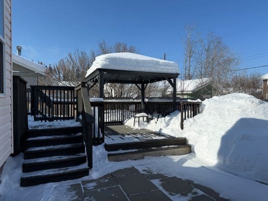 Snow-covered gazebo and deck in winter.