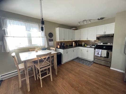 Modern kitchen with white cabinets and table.