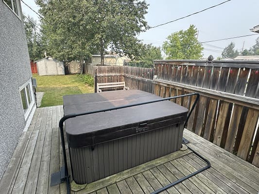 Covered hot tub on wooden deck.