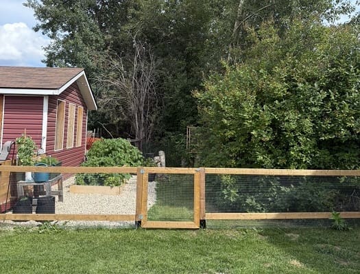 Red house with garden and wooden fence.