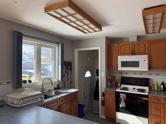 Bright kitchen with wooden cabinets and appliances.