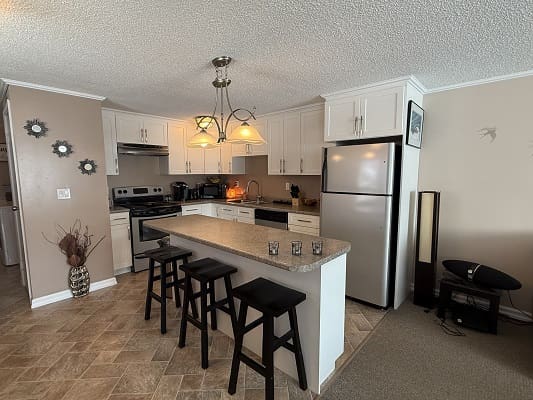 Modern kitchen with island and bar stools.