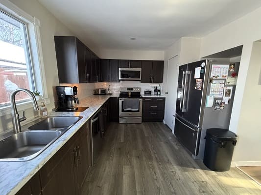Modern kitchen with dark cabinets and appliances.