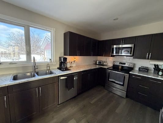 Modern kitchen with dark cabinets and appliances.