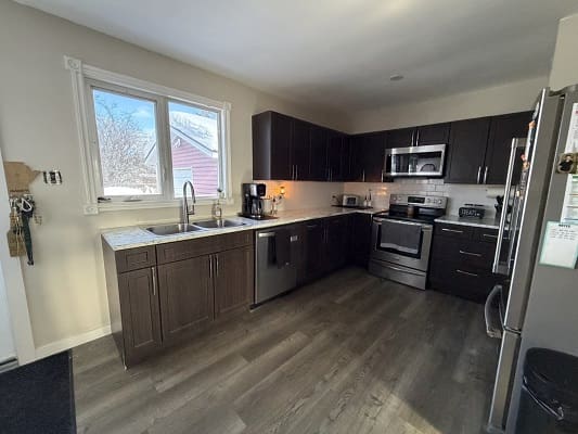 Modern kitchen with dark cabinets and appliances.