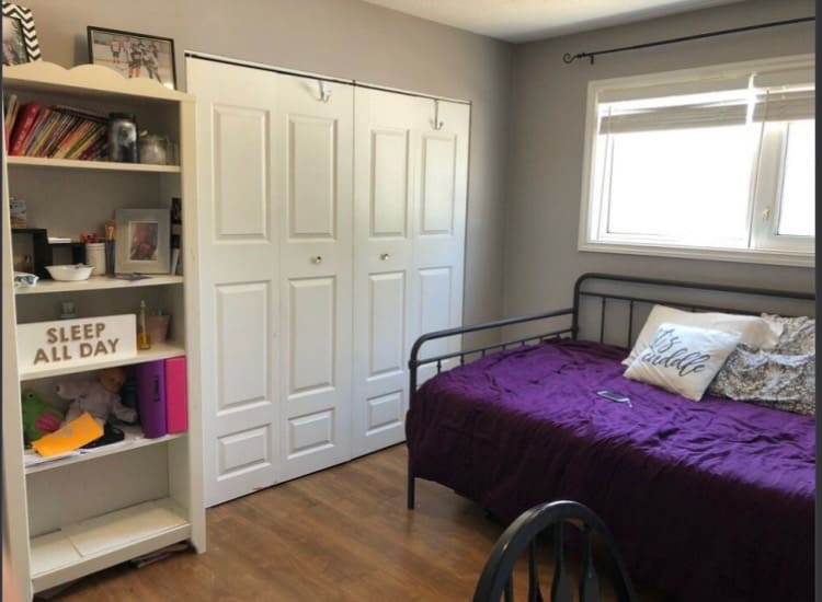 Bedroom with daybed, bookshelf, and window.