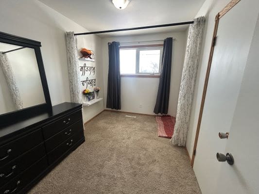 Small room with dresser and window.