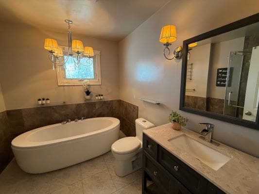 Elegant bathroom with tub and chandelier lighting.